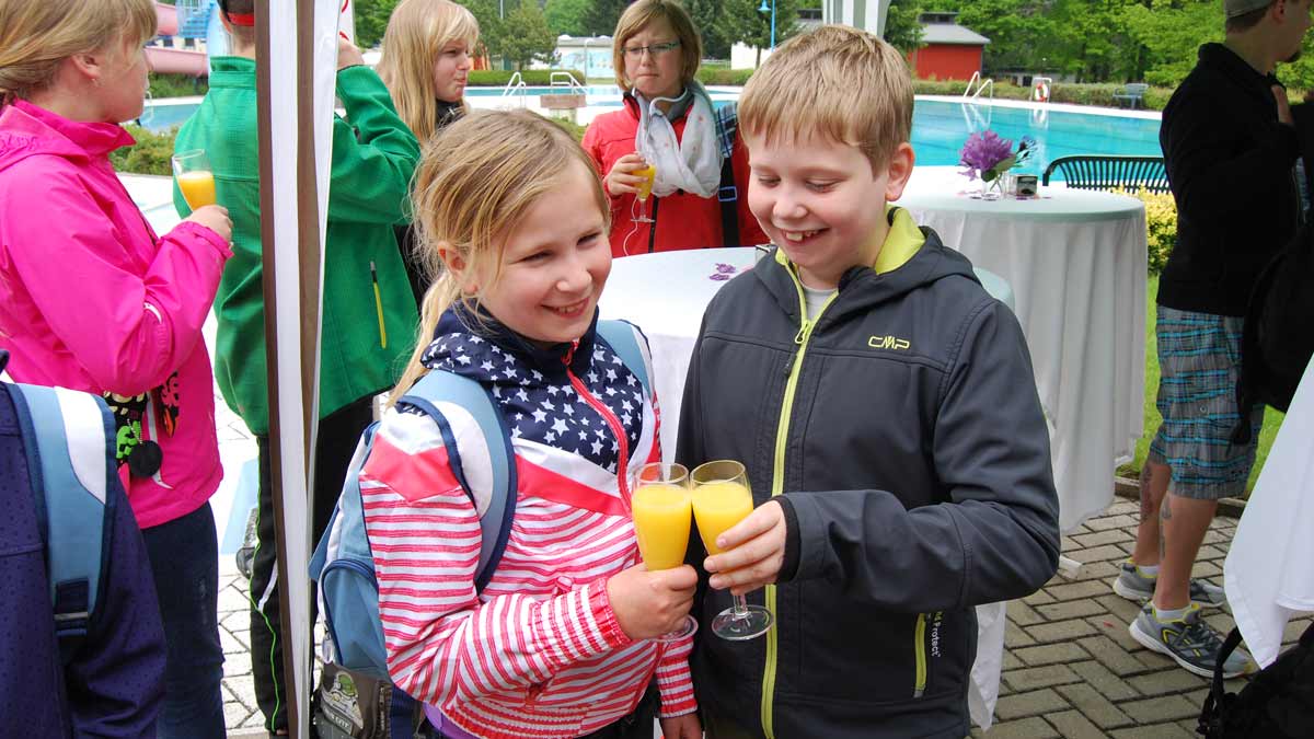 Die Jugendfeuerwehrleute stoßen mit Orangensaft an